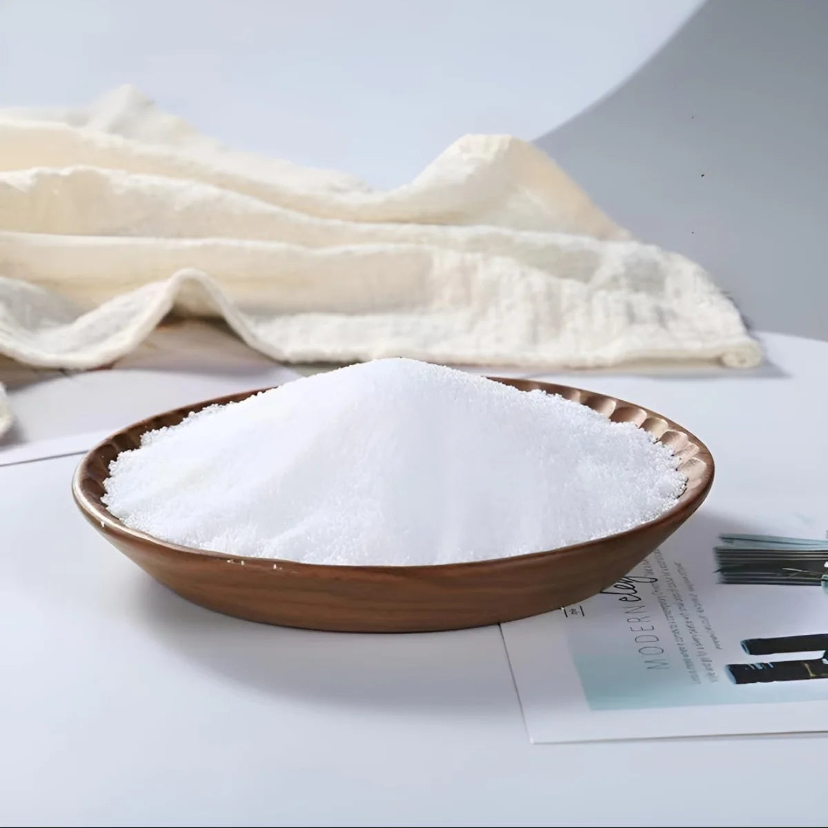 Brown ceramic bowl filled with white candle wax on a light surface with a cloth in the background