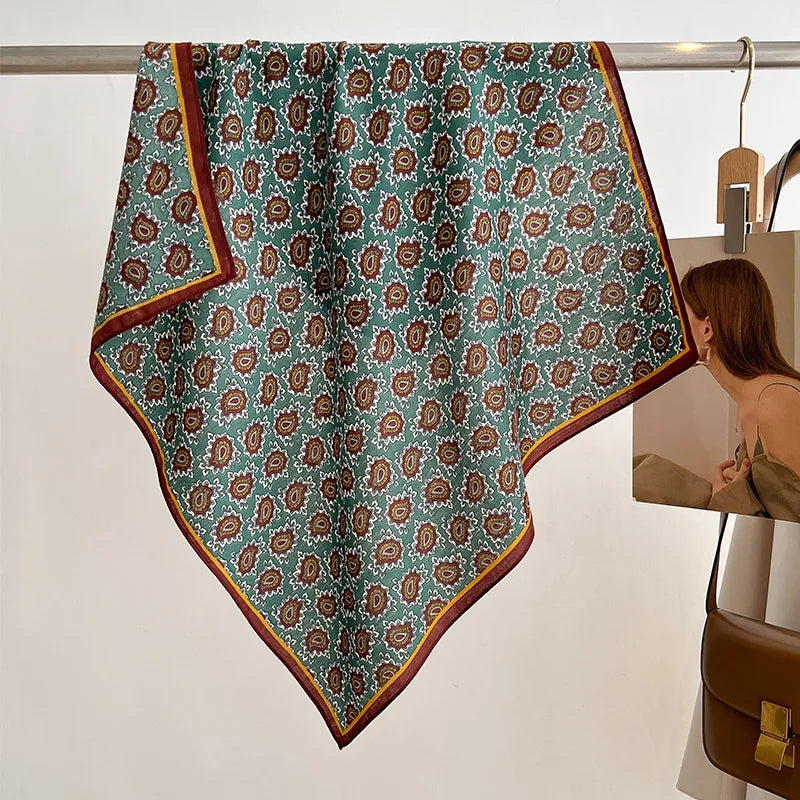 Patterned fabric hanging on a rack with a person in the background.