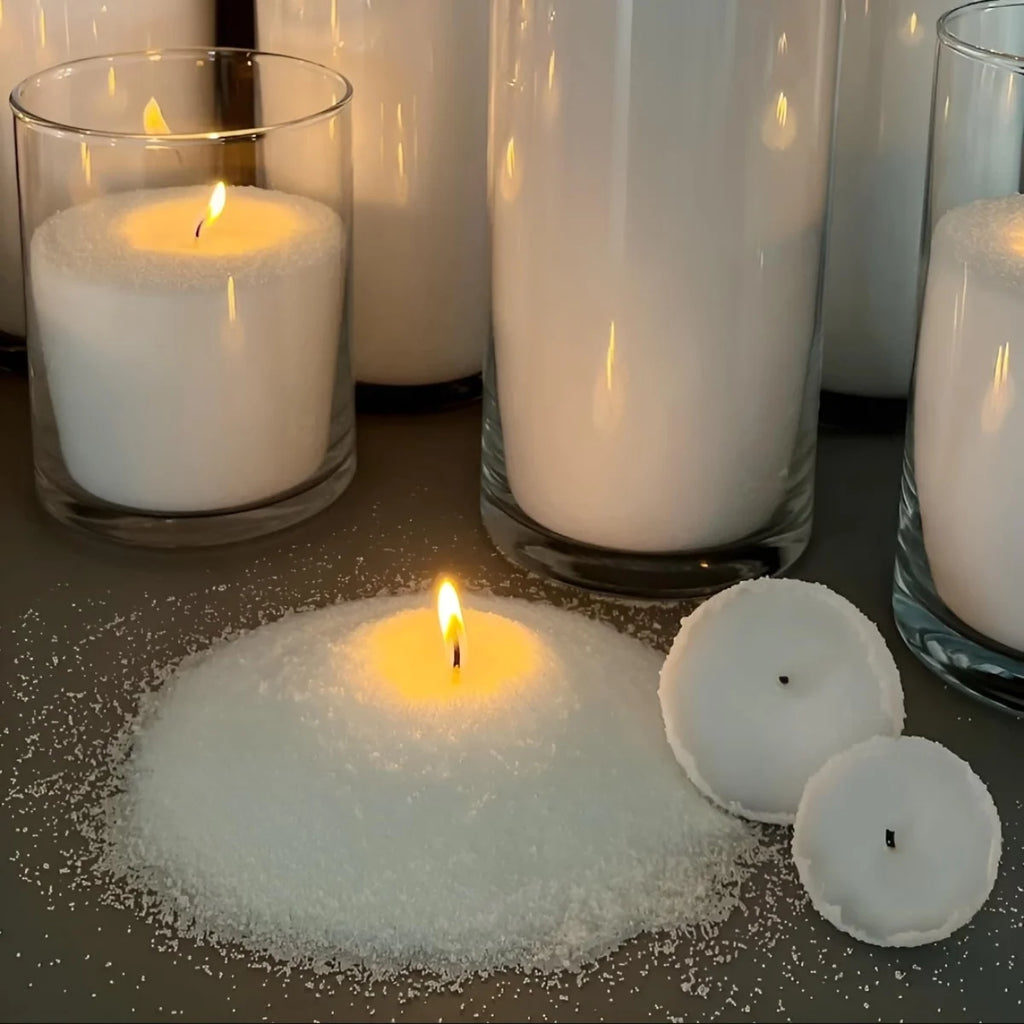 Candles in various containers on a reflective surface