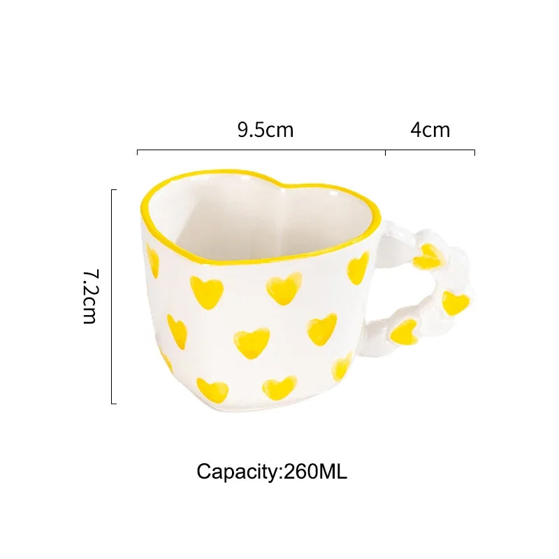 Heart-shaped mug with yellow heart patterns and measurements on a white background