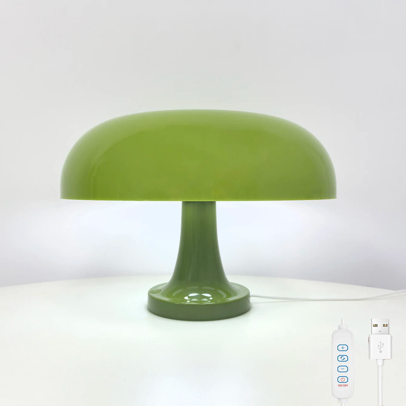 Green table lamp on a white surface with a remote control next to it.