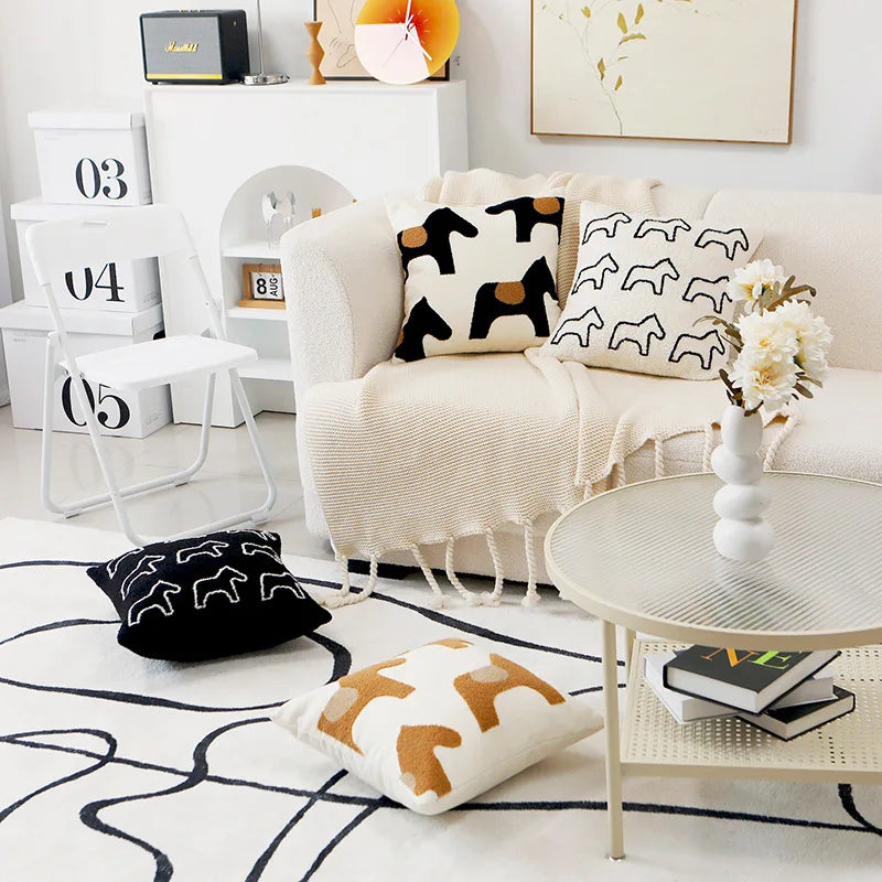 Modern living room with a white sofa, decorative pillows, and a coffee table.