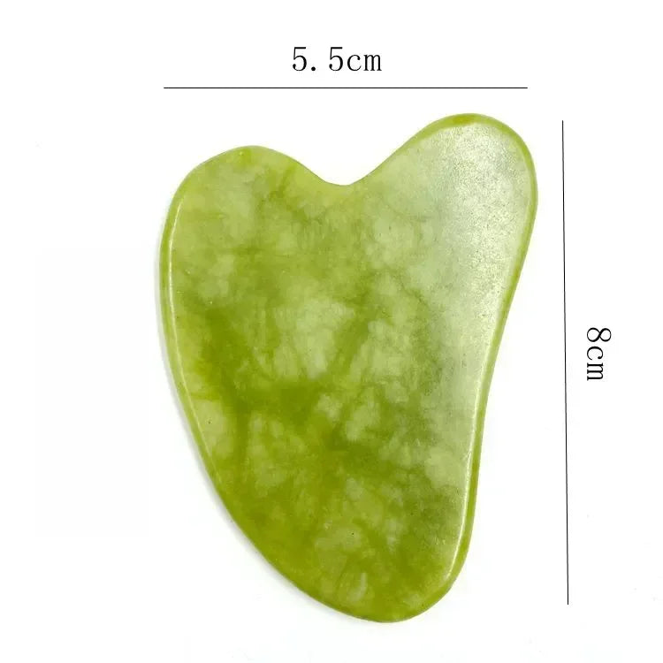 Green jade gua sha tool with measurements on a white background