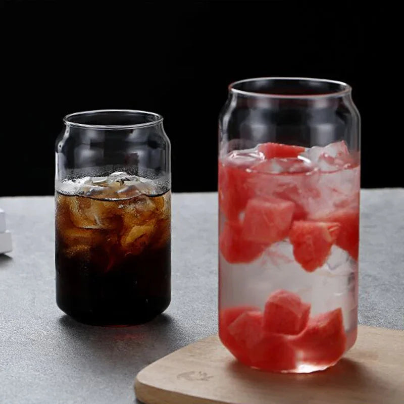 Two glass containers filled with iced beverages on a gray surface.