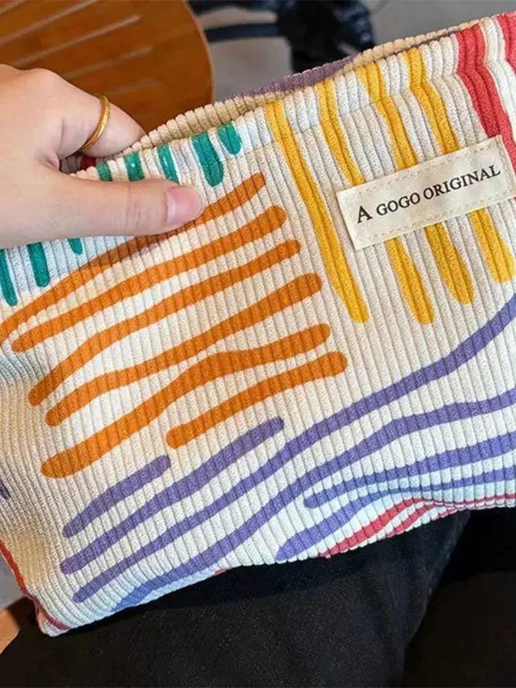 Colorful striped pouch held by a hand with 'A GOGO ORIGINAL' label.