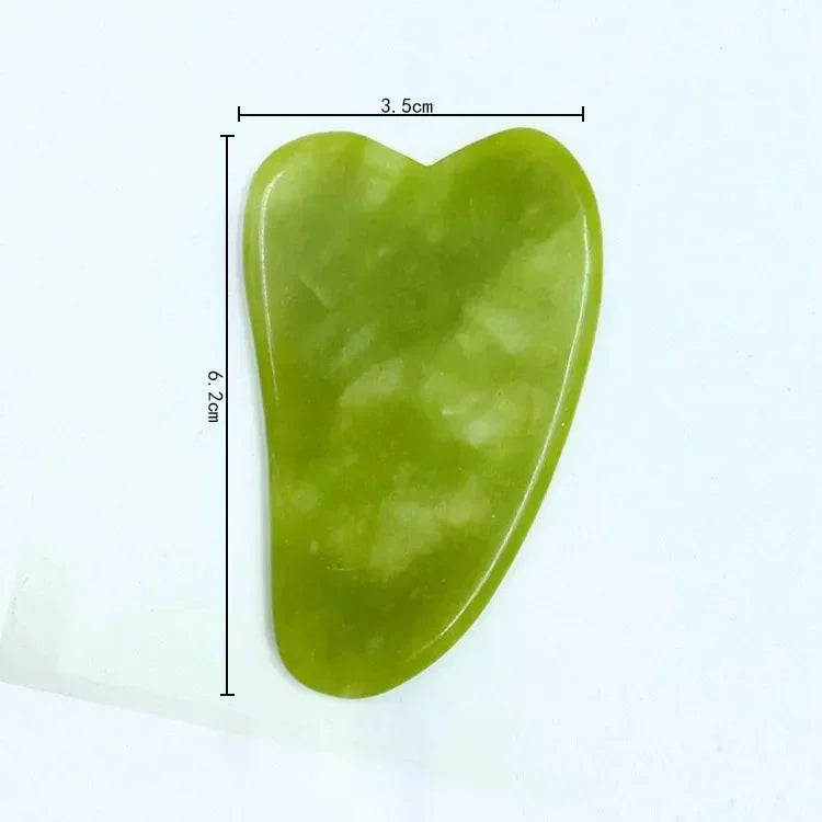 Green jade gua sha tool with measurements on a white background