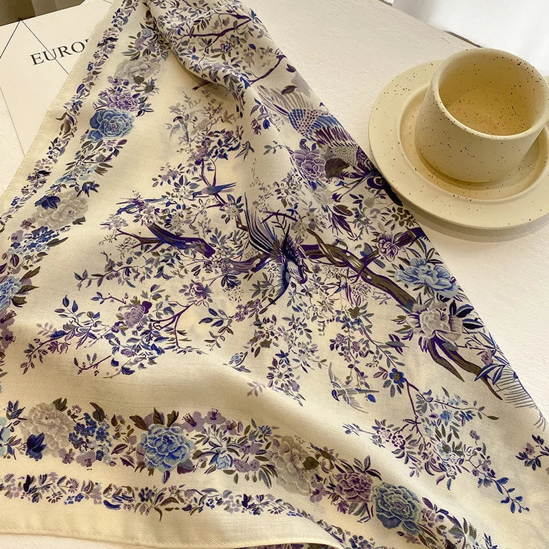Floral and bird patterned fabric on a table with a cup of coffee.
