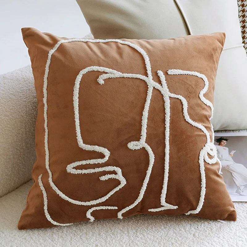 Brown pillow with white abstract design on a beige couch