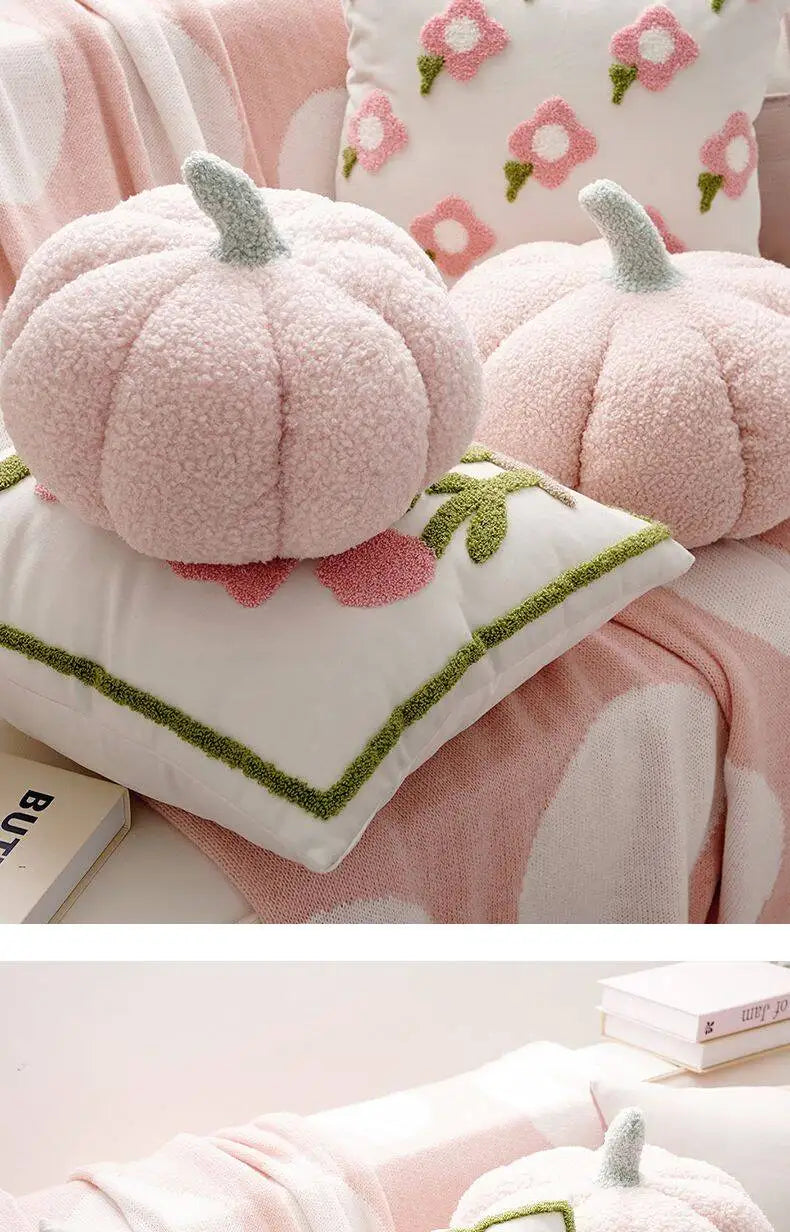 Pink pumpkin-shaped cushions with green stems on a floral pillow