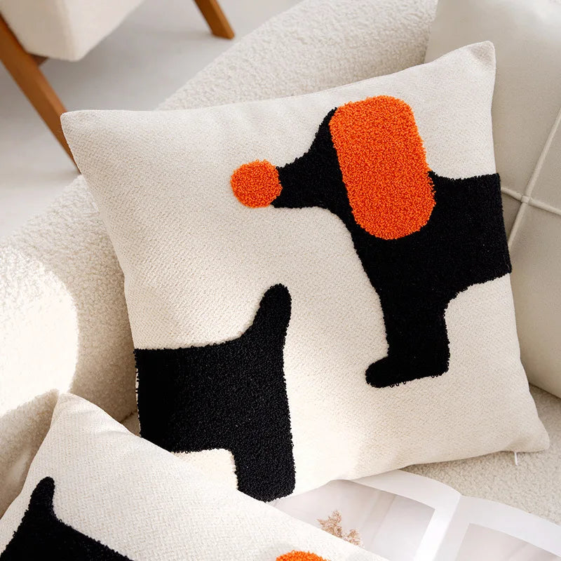 Decorative pillow with black and orange abstract design on a neutral background
