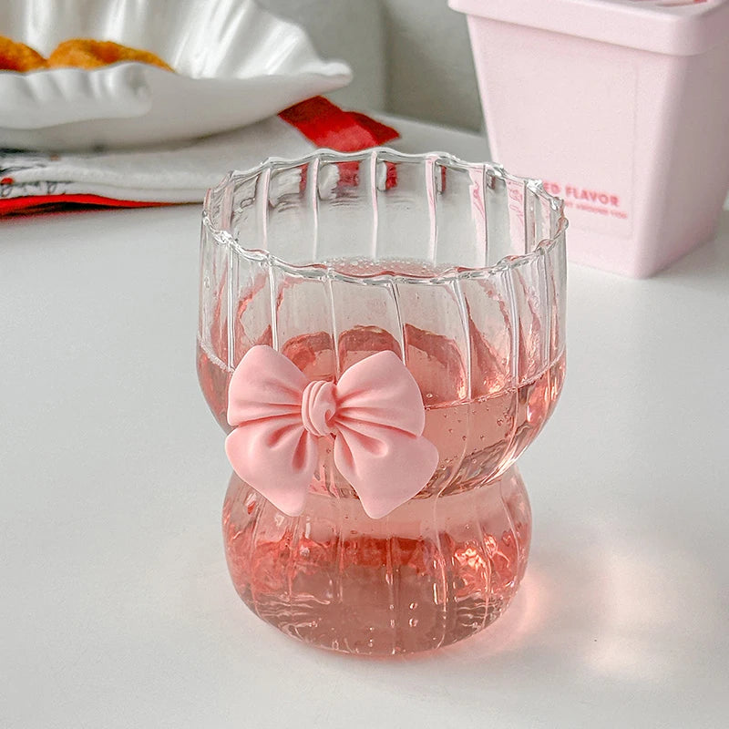 Clear glass with a pink bow on a white surface