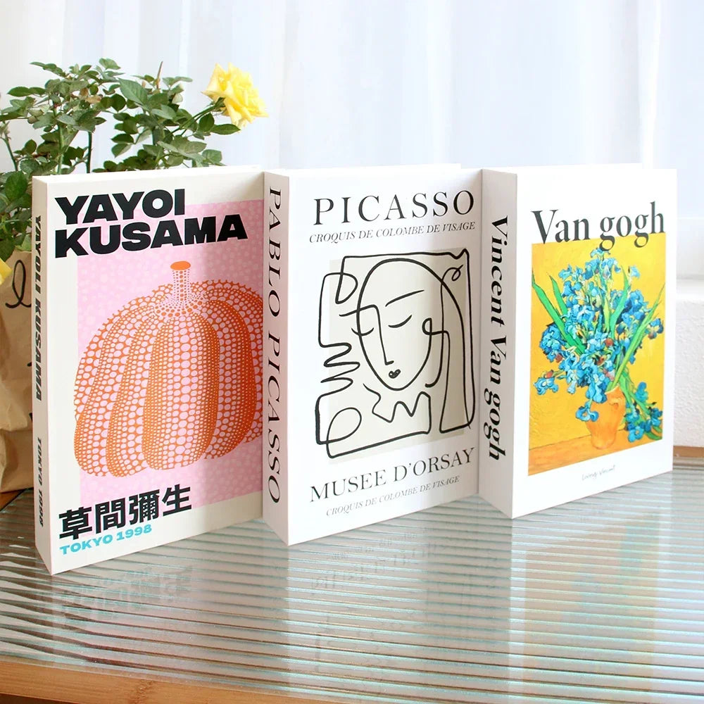 Three fake books on a reflective surface with 'Yayoi Kusama', 'Pablo Picasso', and 'Van Gogh' covers.