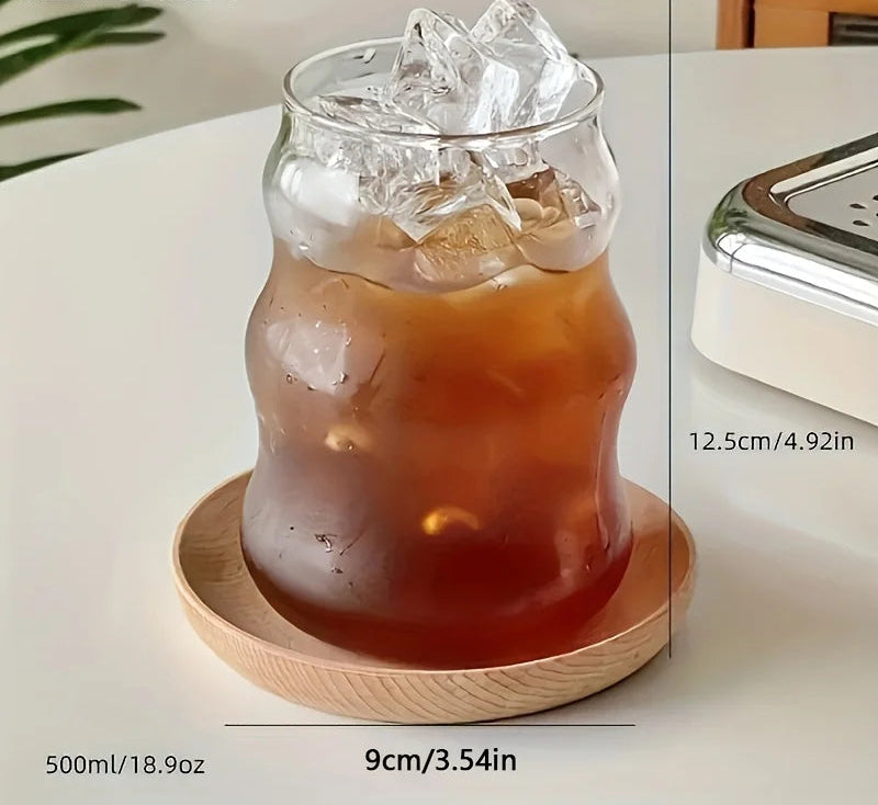 Glass of iced drink on a wooden coaster with measurements displayed