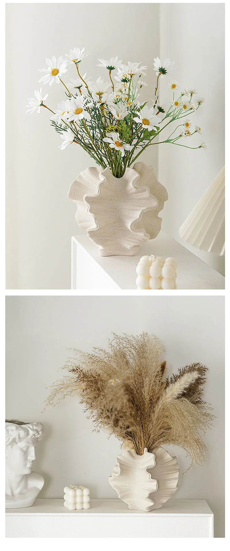 Decorative arrangement of flowers and dried pampas grass in white vases on a white surface.