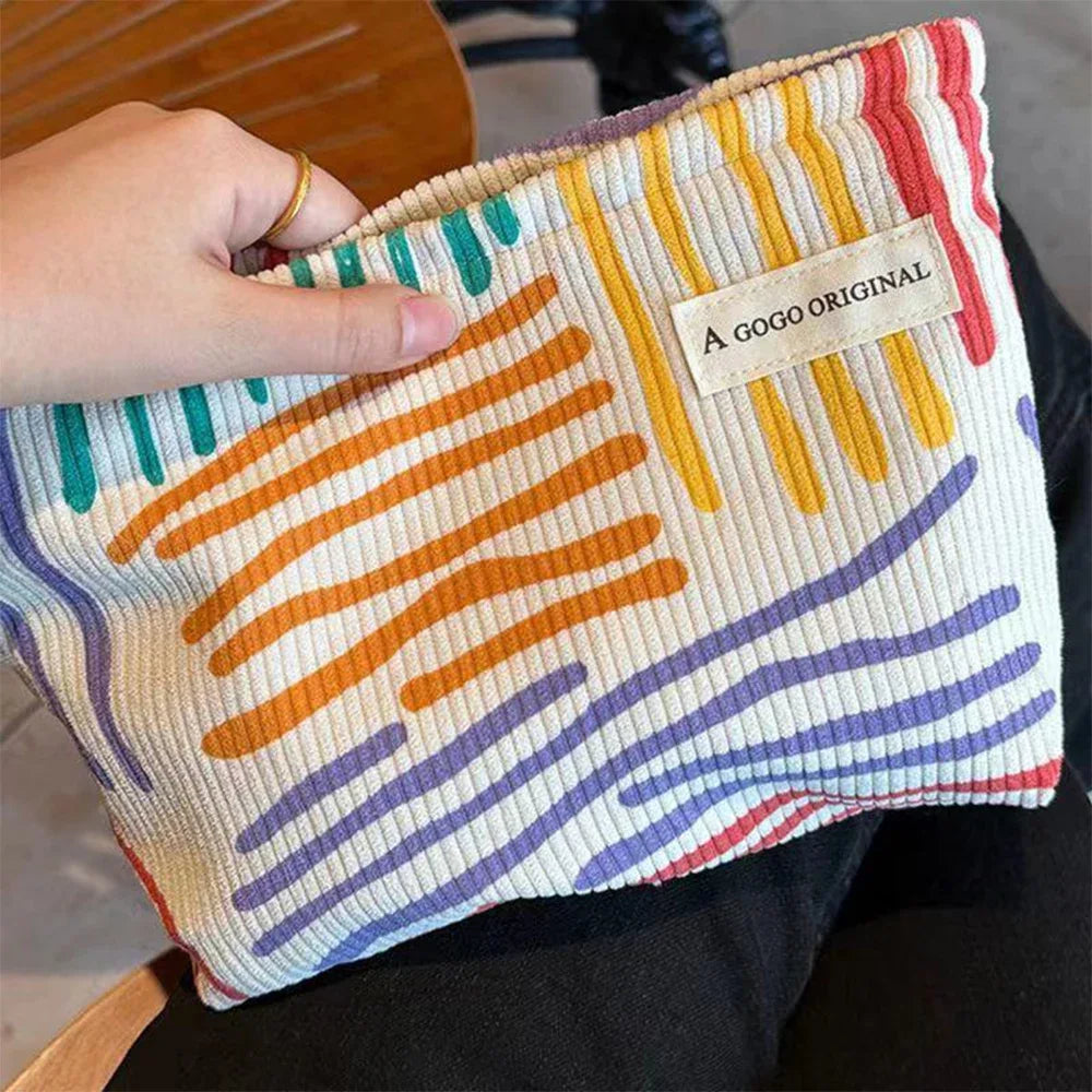 Colorful pouch with abstract patterns held by a hand, featuring 'A Gogo Original' label.
