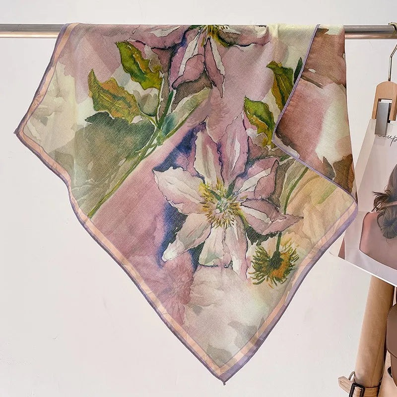Floral patterned scarf on a stand with a white background