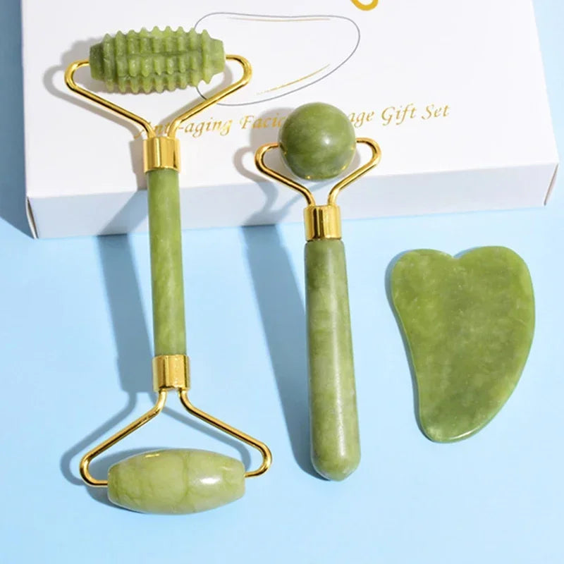 Jade facial roller and gua sha tool set on a light blue background