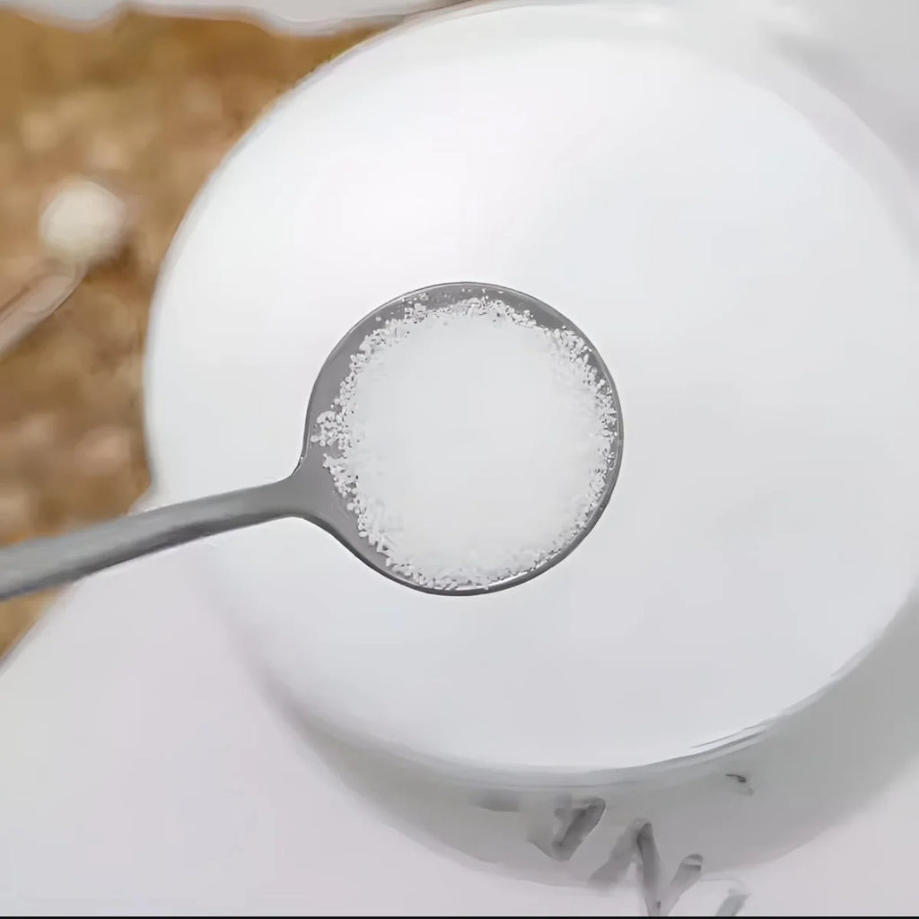 Spoonful of candle wax over a bowl with a blurred background