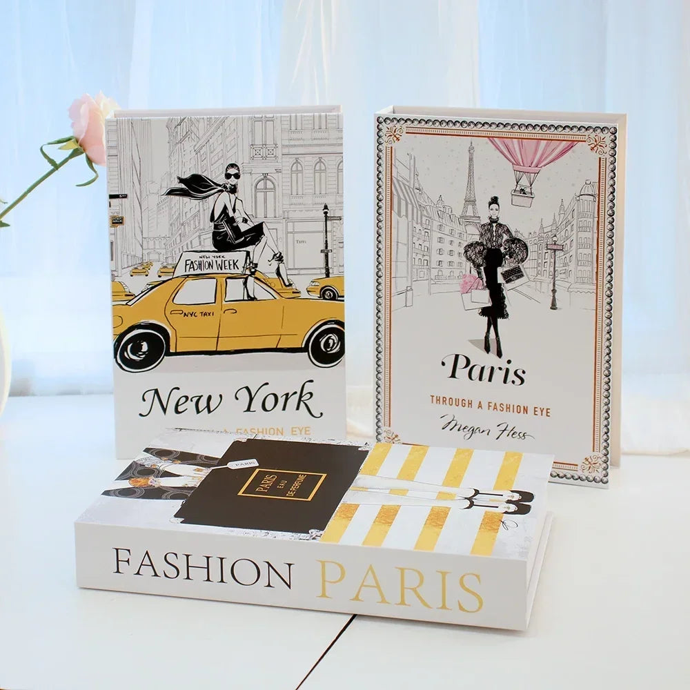 Three fashion-themed books on a light surface with a blurred background