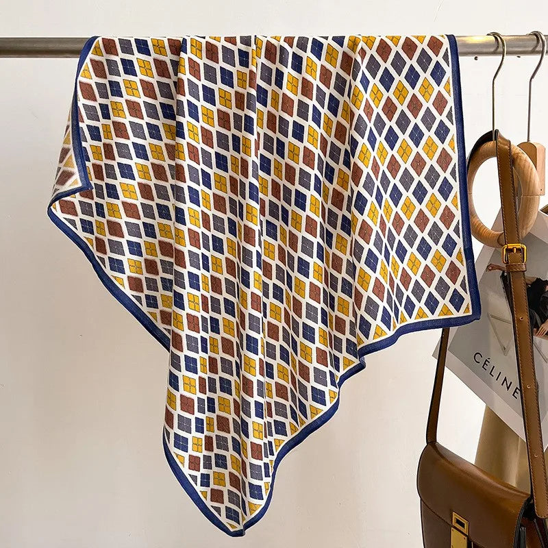 Patterned scarf draped over a rack with a handbag in the background