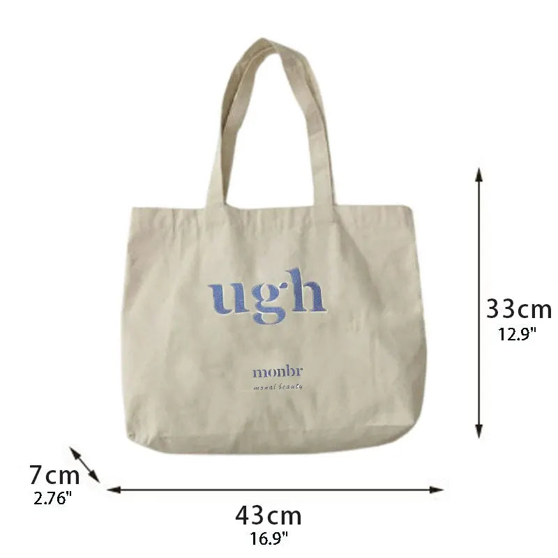 Beige tote bag with 'ugh' text and measurements on a white background