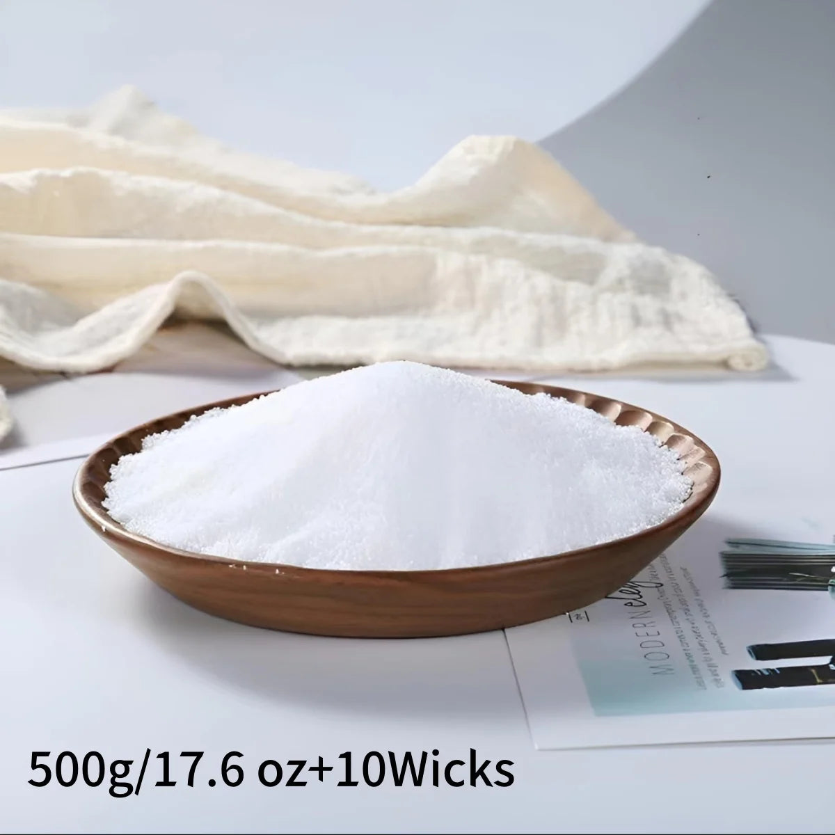 Brown bowl filled with candle wax on a newspaper with a white towel in the background