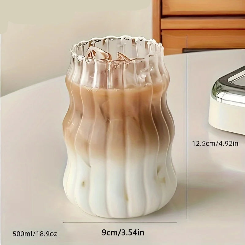 Glass container with layered liquid on a light surface.