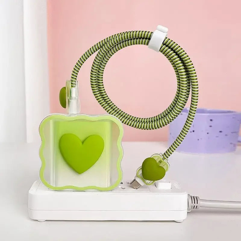 Green heart-shaped charger head protective sleeve on a white base against a pink background