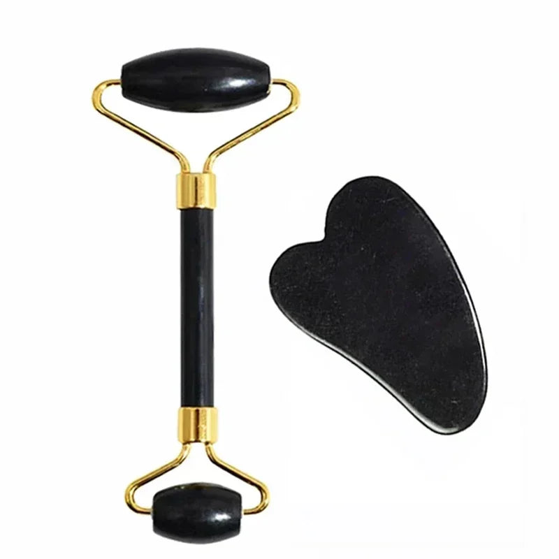 Black and gold facial roller and gua sha tool on a white background
