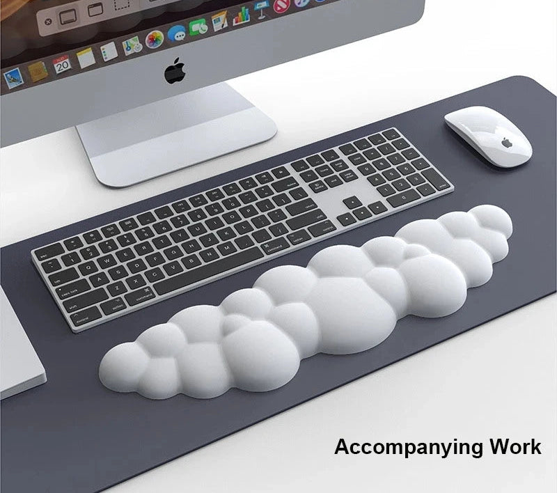 Desk setup with a computer monitor, keyboard, mouse, and cloud-shaped objects.