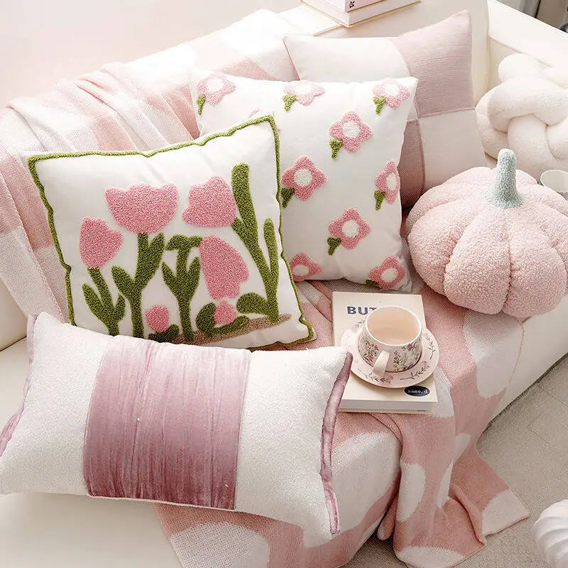 Decorative pillows with floral patterns on a pink couch