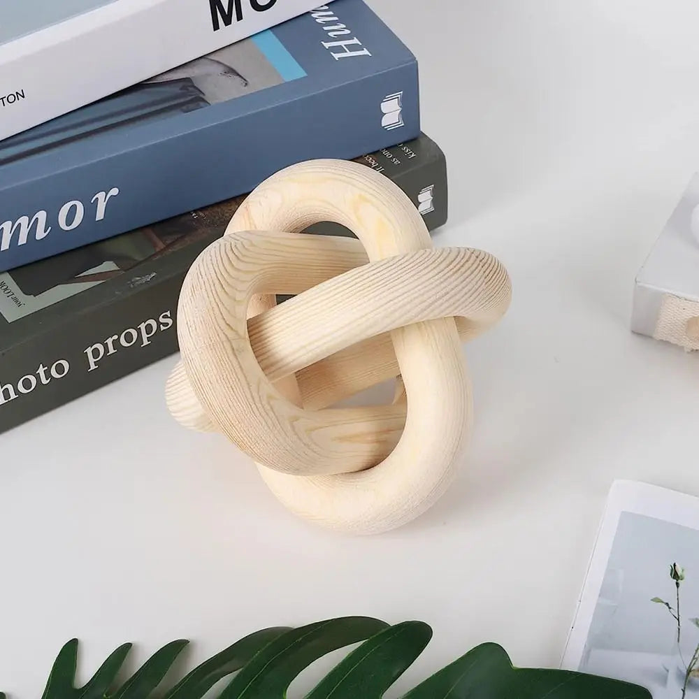 Wooden knot object on a white surface with books in the background