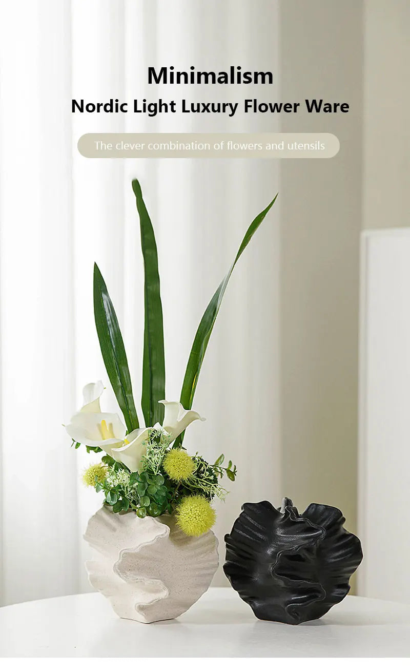Nordic light luxury flower arrangement in a white vase with a black decorative piece on a white surface.