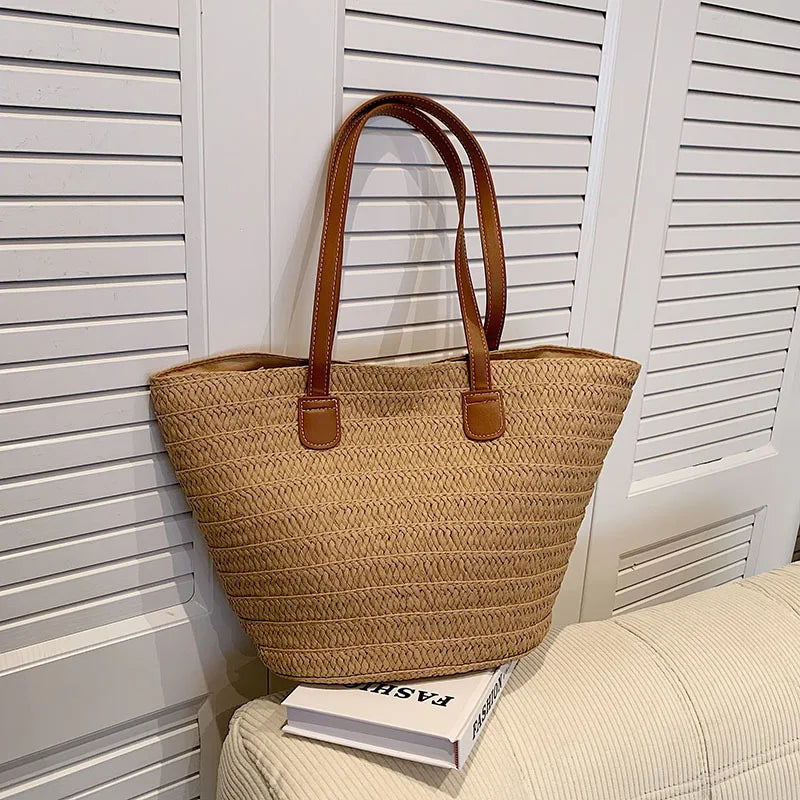 Brown woven tote bag with brown handles on a white surface