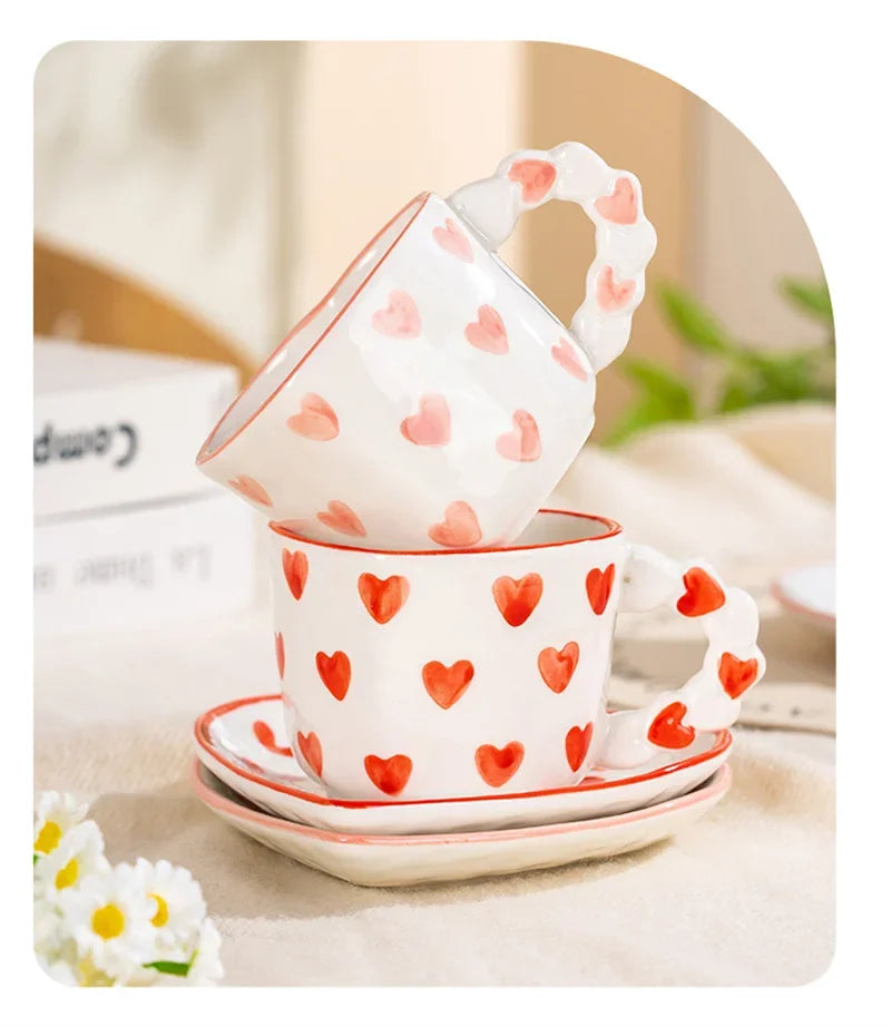 Ceramic cup with heart pattern on a saucer, placed on a surface with a blurred background.