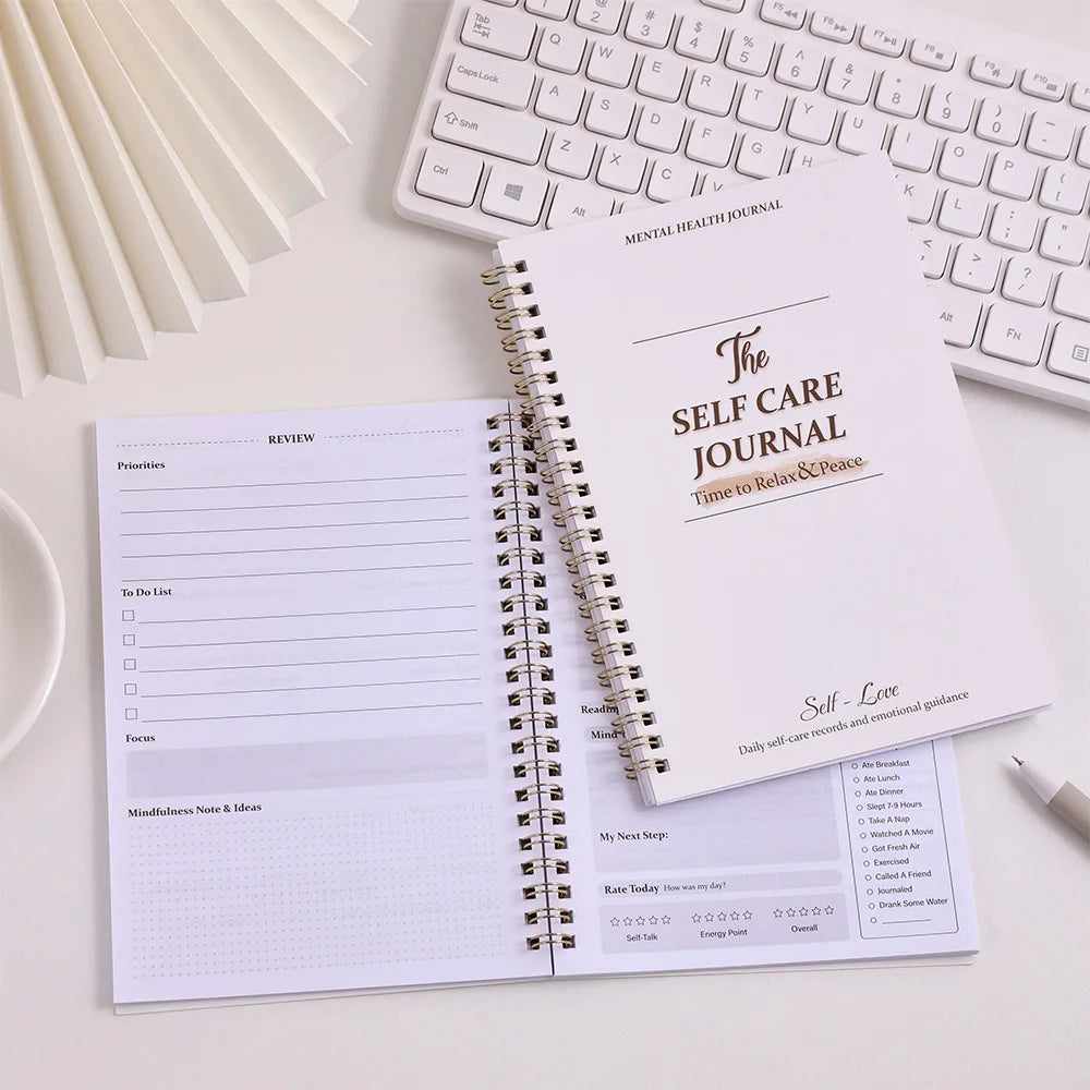 Self-care journal on a desk with a keyboard
