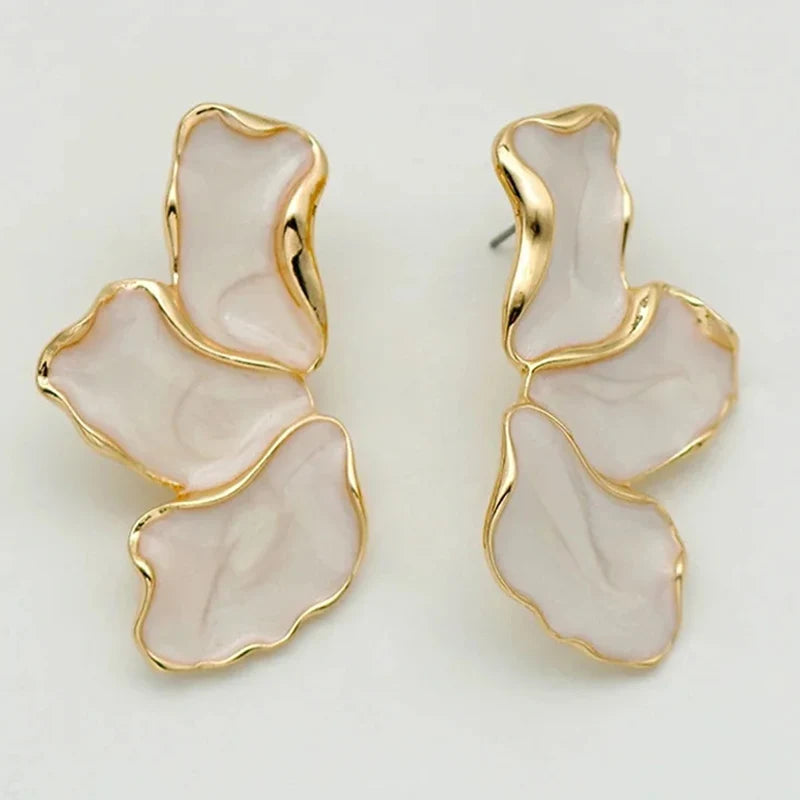 Gold-framed earrings with a pearl shade center on a white background
