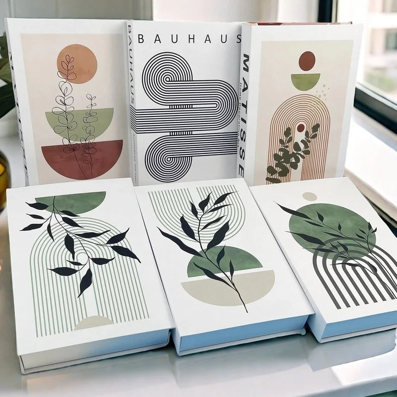 Collection of books with abstract designs and text on a white surface.