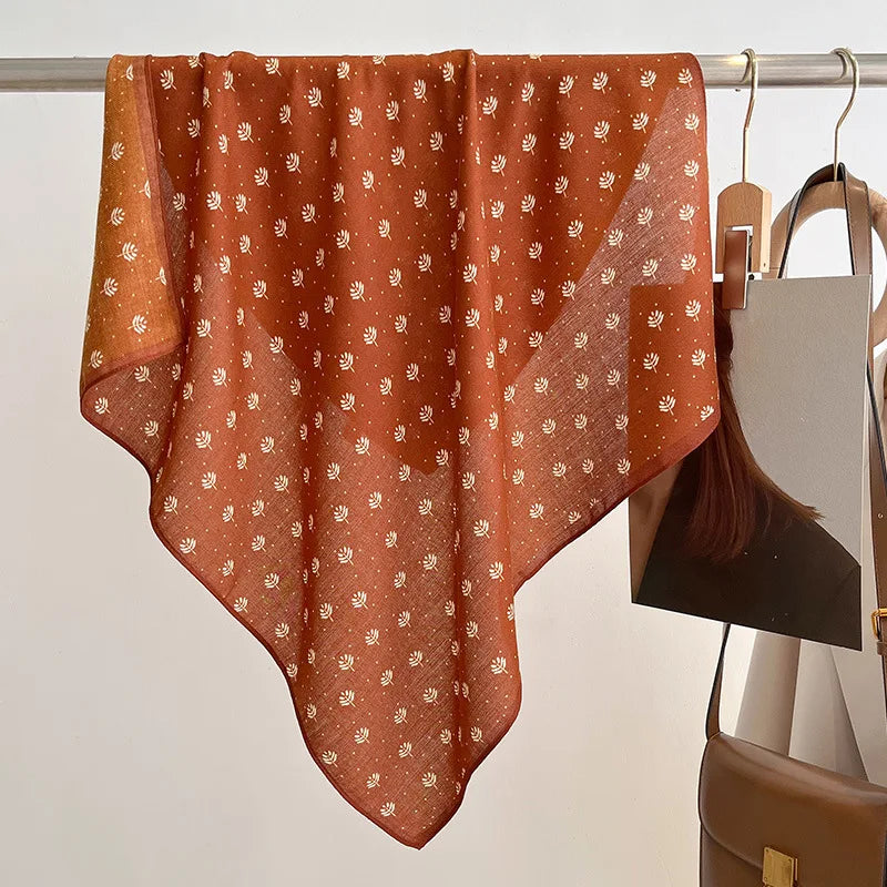 Brown patterned fabric draped over a rack with a neutral background