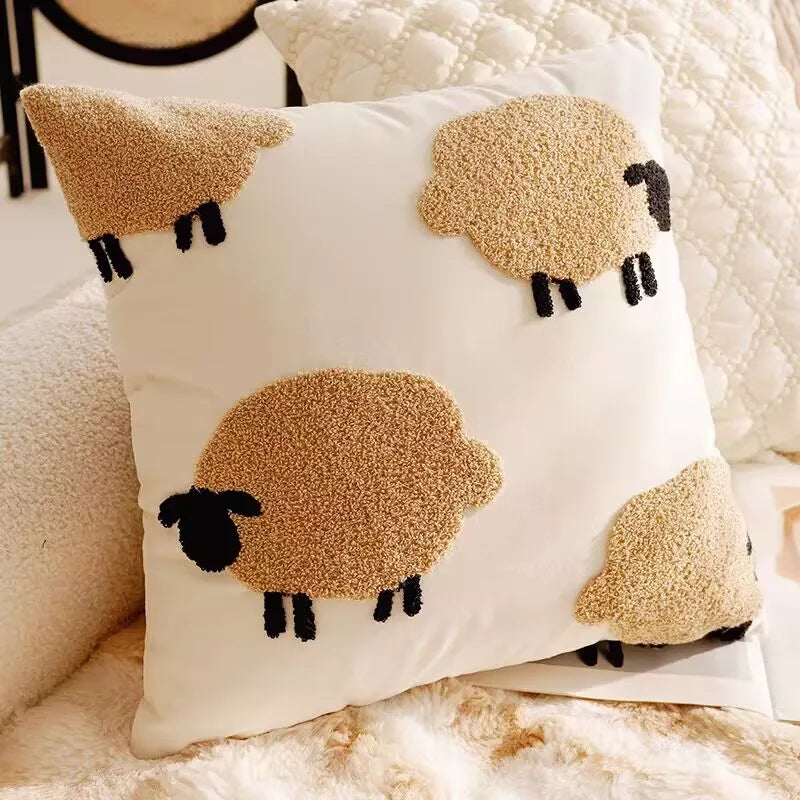 Decorative pillow with sheep designs on a soft surface