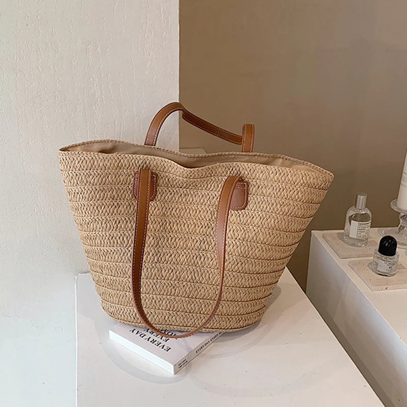 Woven straw bag with brown handles on a white surface
