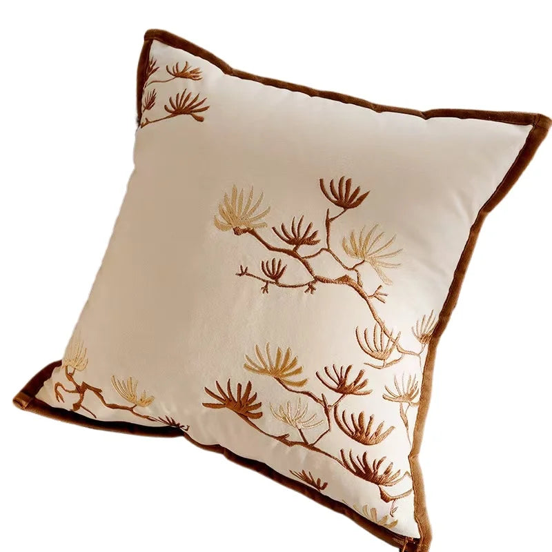 Decorative pillow with brown floral embroidery on a beige background
