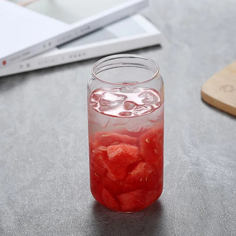 Clear glass with watermelon pieces and red liquid on a gray surface