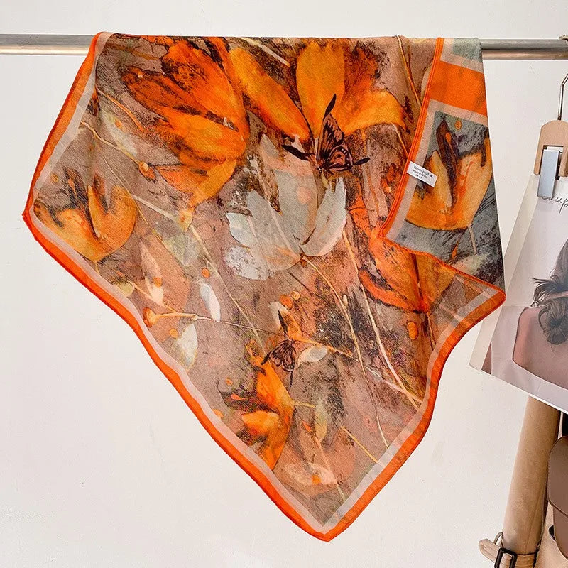 Floral patterned scarf with orange and brown colors on a white background