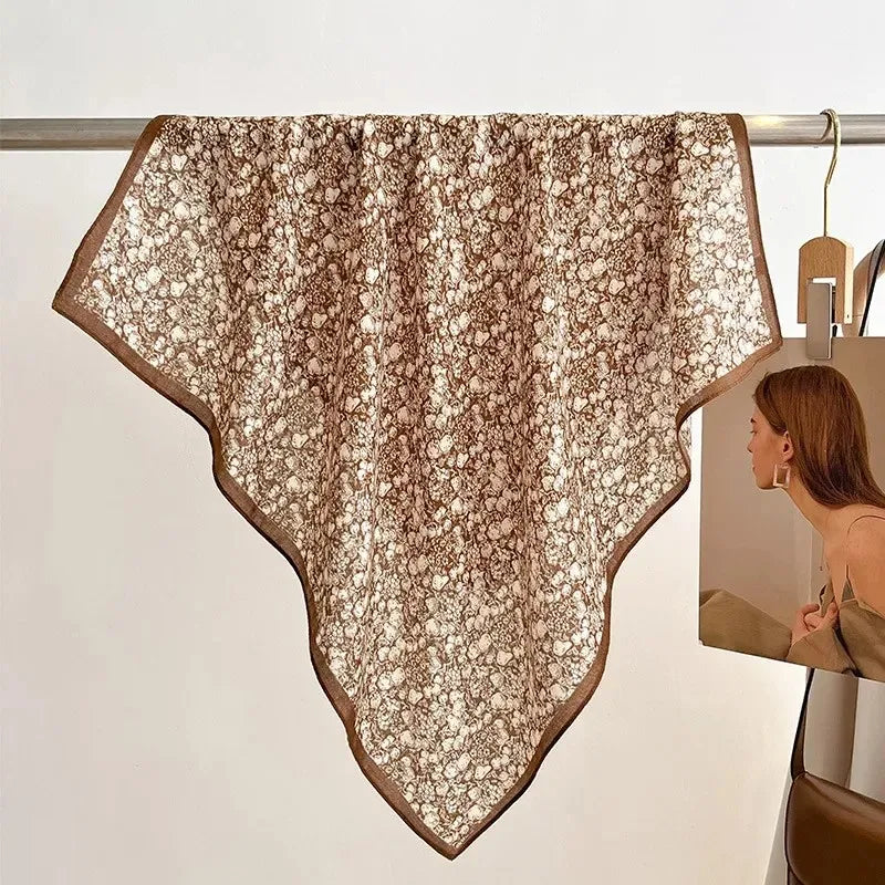 Brown lace scarf draped over a rack with a neutral background