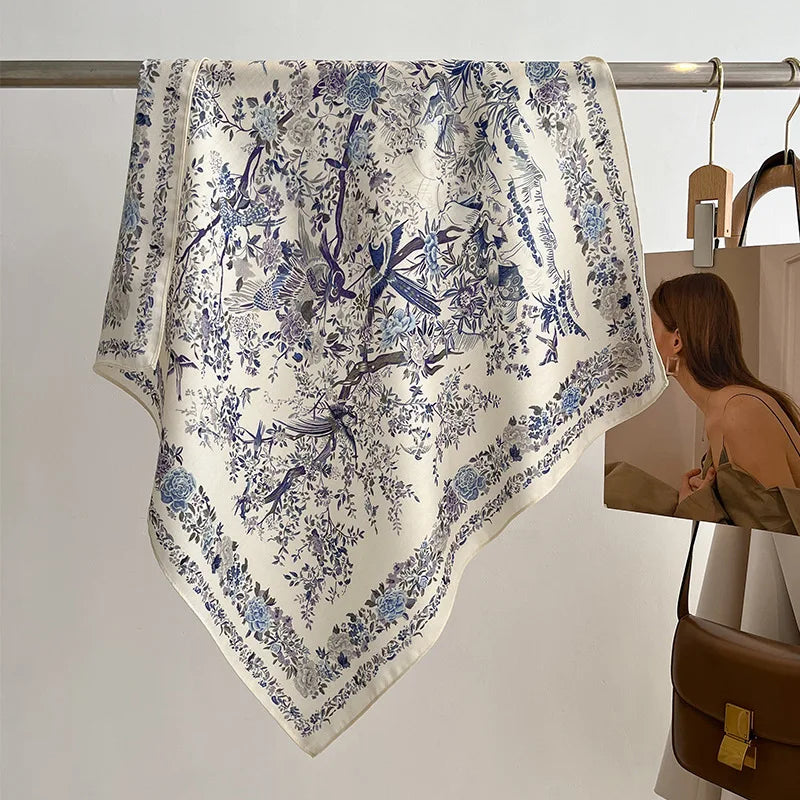Floral patterned scarf hanging on a rack with a person in the background.