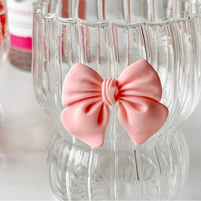 Pink bow-shaped object on a clear glass container