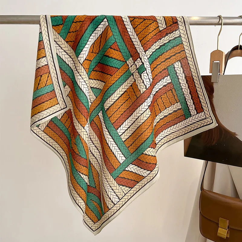 Colorful patterned scarf draped over a rack with a handbag in the background.