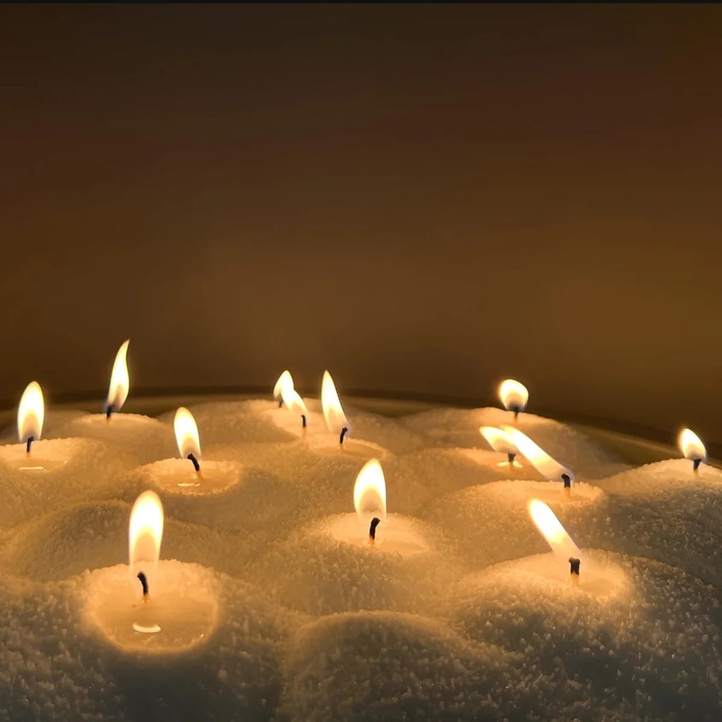 Multiple lit candles on a dark background