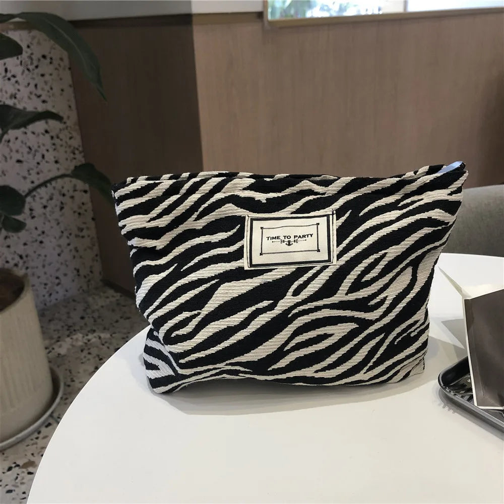 Zebra patterned pouch with a label on a white surface